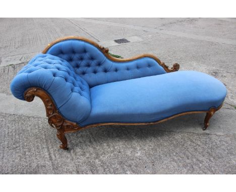A late 19th century shape-back chaise longue, button upholstered in a blue fabric, on cabriole castored supports, 72" long x 