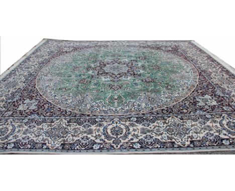 A large Egyptian wool carpet, worked with an all over foliate design, with central circular green panel within a cream border