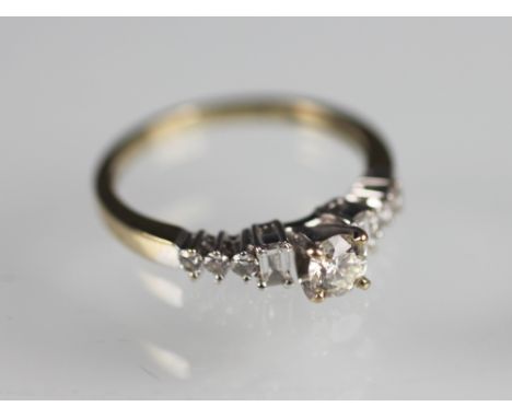 A diamond nine stone ring, designed as a central brilliant cut diamond flanked by a baguette cut diamond to either side and t