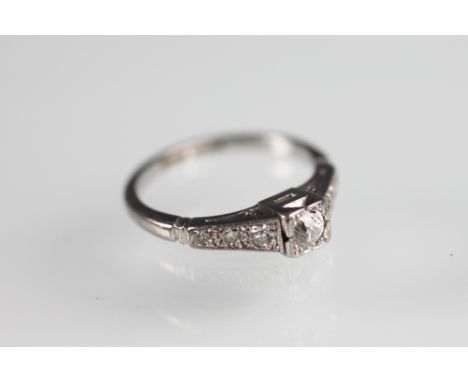 A diamond ring, the central old brilliant cut diamond within an Art Deco square setting, within tapering diamond set shoulder