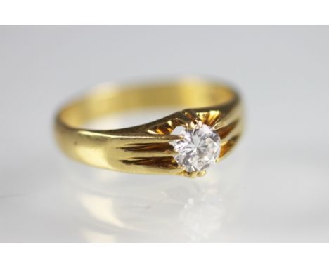 A diamond set ring, the brilliant cut diamond (of approximately 0.60ct) gypsy set in 18ct yellow gold to the plain polished b