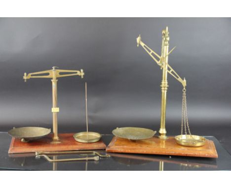 A set of Avery brass apothecary scales, on mahogany plinth, 60cm, a pair of F. Quiney & Sons brass apothecary scales, and a s