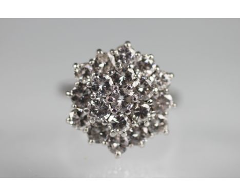 A diamond set hexagonal cluster ring, set with nineteen brilliant cut diamonds all claw set to the tapering shoulders and pla
