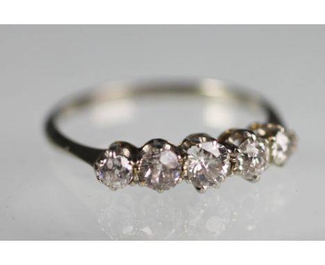 A five stone diamond ring, the five graduated old brilliant cut diamonds all claw set in white metal, unmarked, weight 2.4gms