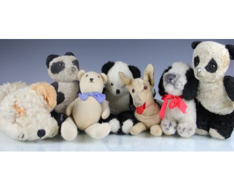 A Merrythought Alsatian soft toy, a Merrythought nightdress case, another Merrythought dog, a panda teddy bear with defective