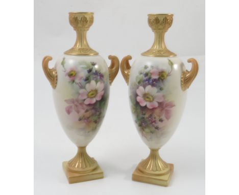 A pair of Royal Worcester pedestal vases, decorated with roses and violets, to blush and gilt twin handles and neck to a simi