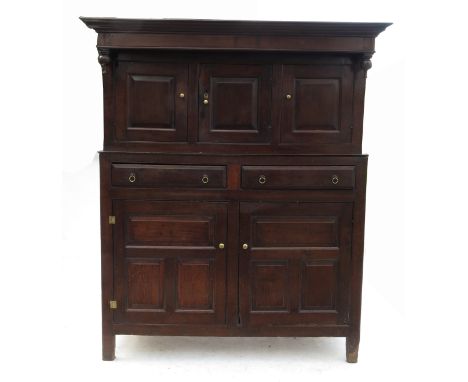 An 18th century oak deudarn, the upper section fitted with three fielded panel cupboard doors, the central cupboard opening t