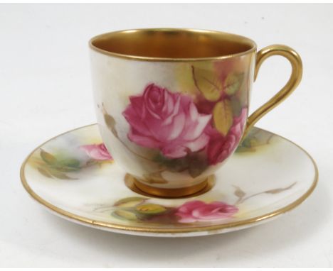 A Royal Worcester cabinet cup and saucer, hand painted to the exterior of the cup and saucer with roses by M Hunt, af, dated 