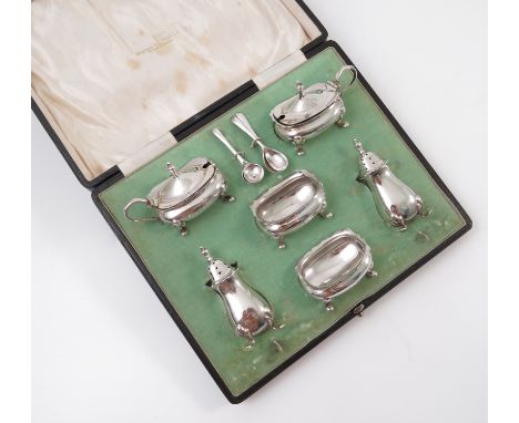 A cased six piece silver condiment set, comprising two peppers, two open salts, two mustard pots and four spoons, with shaped