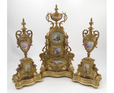 A 19th century French gilt metal mantel clock garniture, the striking movement numbered 129 5 8, the dial painted with a land