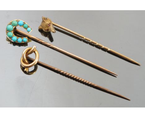 A fox mask stick pin, with cabochon ruby eyes, together with a turquoise horse shoe stick pin, and a lovers knot stick pin 