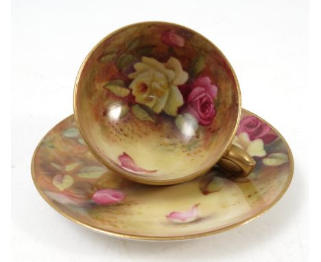 A Royal Worcester cabinet cup and saucer, the interior of the cup and the saucer hand painted with roses to a mossy backgroun