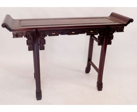 A Chinese hardwood altar table with scroll over end and blind fretwork carved frieze, 125cm wide x 36cm deep x 85cm tall 