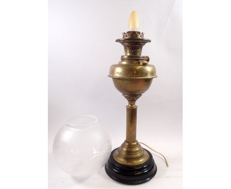 A brass oil lamp with reeded stem and etched globe converted to electric, 65cm tall 