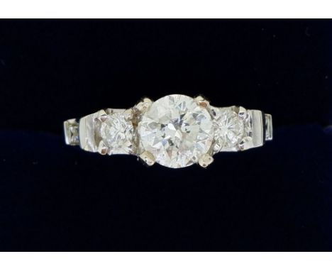 An 18 ct white gold diamond ring with three brilliant cut diamonds flanked by two baguette cut diamonds, 1.8cts iin total, si