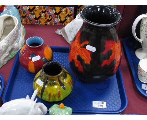 Poole Pottery Vase, featuring autumn leaves on black ground, 21cm high, two smaller examples. (3)large vase has scratches