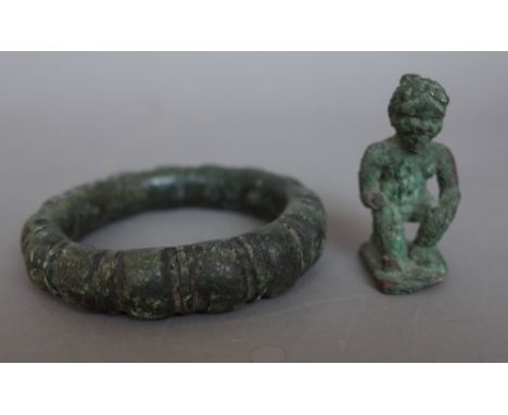 Antiquities; a verdigris iron bangle of circular form and a small metal figure, 5cm high, (2).  