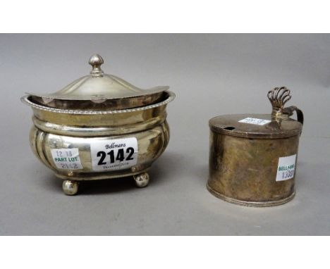 Silver, comprising a hinge lidded tea caddy of compressed oval form, raised on four spherical feet, Birmingham 1919 and a Geo
