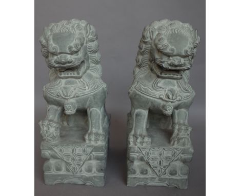 A pair of modern stone Chinese lions or 'Dogs of Fo', seated on a foliate carved base , 31cm high and a modern pottery Chines