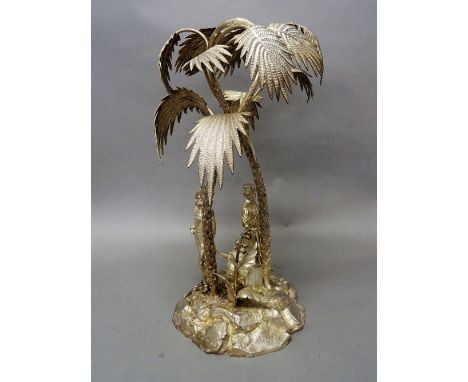 A Victorian silver table centrepiece, modelled as two palm trees raised on a rocky base, mounted with the standing figures of