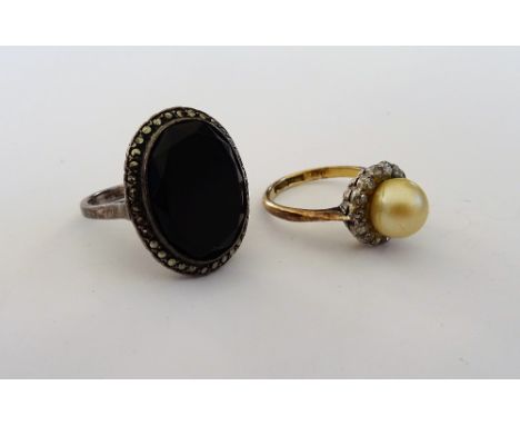 A gold, imitation pearl and diamond cluster ring, mounted with an imitation pearl in a surround of cushion shaped diamonds an