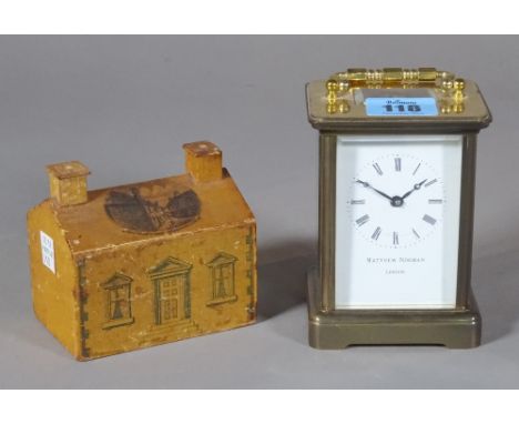 Matthew Norman; a 20th century brass carriage clock, 8cm wide x 11cm high, and a 20th century painted wooden money bank, 10cm