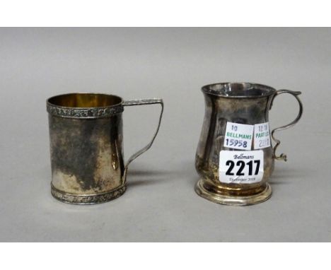 A George III silver small mug of baluster form, with a scrolling handle, crest engraved, raised on a circular foot, London 17
