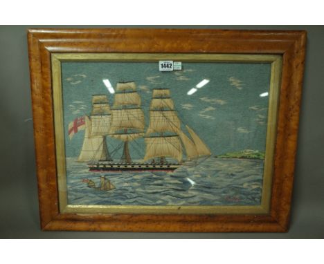 A woolwork ship picture depicting a 19th century warship, fully rigged at sea with land behind 48cm x 36cm, framed and a need