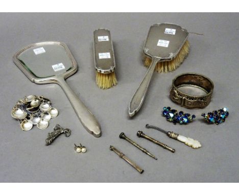 A silver mounted three piece composite dressing set, comprising; a hand mirror and a hairbrush, Birmingham 1965 and a clothes