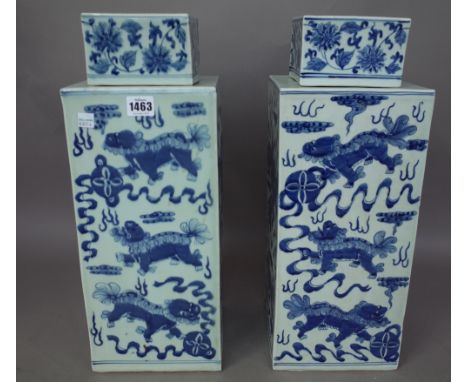 A pair of modern Chinese blue and white porcelain vases and covers each of square section, decorated with dragons chasing a f