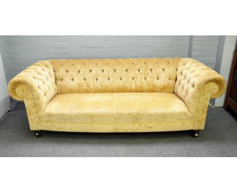 A Chesterfield sofa with buttoned gold upholstery on turned supports, 222cm wide x 74cm high. 