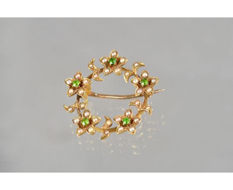 A gold, demantoid garnet and seed pearl set brooch, in a circular design, with five flowerheads, each centred by a demantoid 