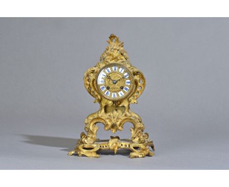 A French rococo style ormolu mantel clock, late 19th century, the foliate scroll case with inset enamel Roman numerals enclos