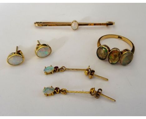 A gold bar brooch, mounted with an oval opal, detailed 15 CT, a gold and water opal three stone ring, a pair of opal single s