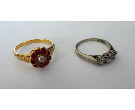 A gold, ruby and half pearl set cluster ring, mounted with the half pearl to the centre, in a surround of nine cushion shaped