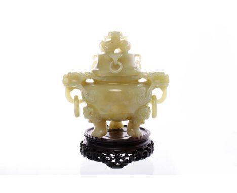 20TH CENTURY CHINESE JADE LIDDED CENSERthe handles modelled as foe dogs, on a carved wooden stand, the censer 19cm high 