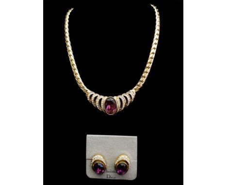 Christian Dior costume jewellery - a yellow metal flat link necklace set with oval purple stone flanked by four rolls of 'c' 