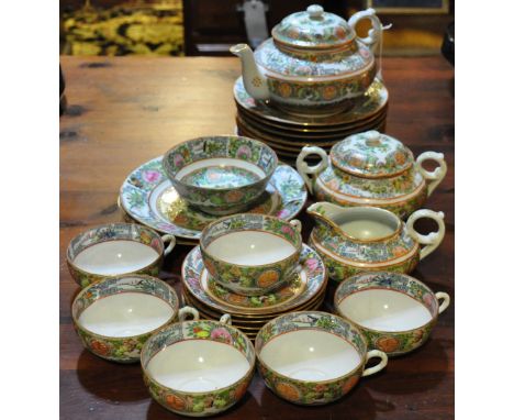 A Cantonese porcelain tea service for six, comprising a teapot, milk jug, lidded sugar bowl, six cups and saucers, eight side