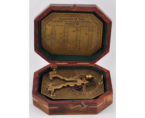 A brass sundial compass in a wooden box