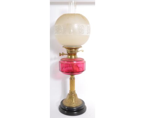 A Victorian 19th century cranberry glass oil lamp. Gilt brass with cranberry reservoir complete with frosted shade having flu