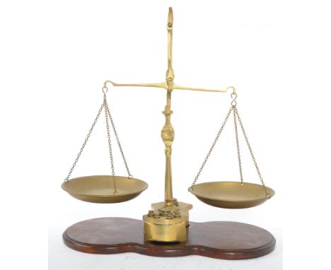 A pair of oak and brass scales complete with the weights. The brass scales with twin pans complete with a set of brass weight