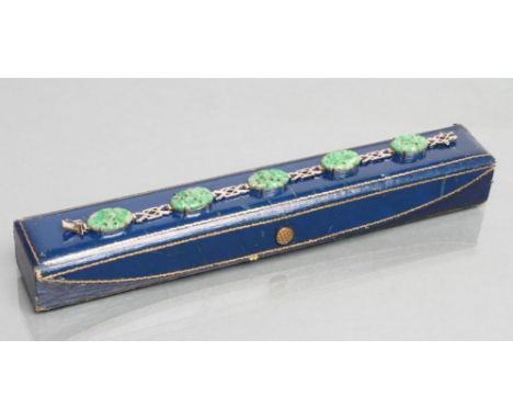 AN ART DECO JADE BRACELET, the five foliate carved and pierced oval panels claw set to angular links, clasp stamped C&F, 9ct,