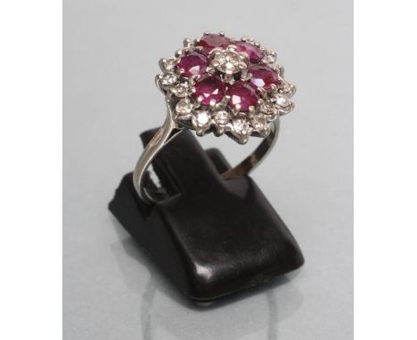 A RUBY AND DIAMOND CLUSTER RING, the six circular facet cut rubies with numerous small round brilliants between, to a plain 1