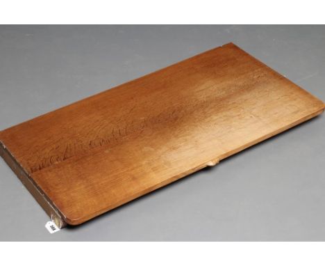 A ROBERT THOMPSON OAK WALL SHELF of rounded oblong form with carved mouse trademark in high relief, supported by end brackets