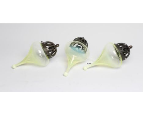 A SET OF THREE VASELINE GLASS LIGHT PENDANTS, late 19th century and later,  the domed and pierced gun metal gallery hanging a