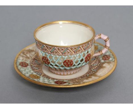 A LATE VICTORIAN ROYAL WORCESTER CHINA RETICULATED CABINET CUP AND SAUCER, 1881 (saucer) and 1882, the honeycomb pierced pane