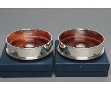 A PAIR OF SILVER BOTTLE COASTERS, maker John Bull Ltd., London 1997, of plain cylindrical form with picture hallmarks, the tu