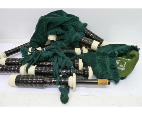 A set of bagpipes in a wooden case, with book Scots Guards standard settings of pipe music, volume 1