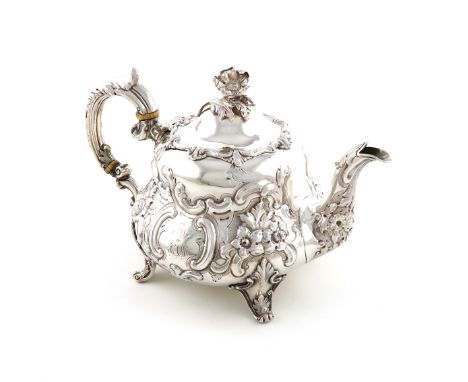 λA Victorian silver teapot, by William Hunter, London 1851, circular bellied form, embossed foliate scroll decoration, leaf-c