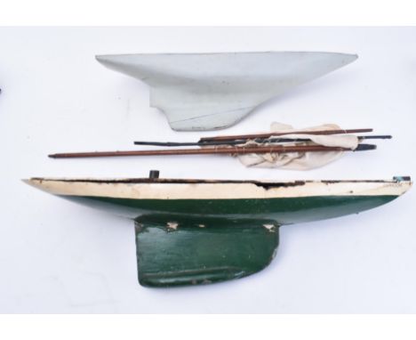 Two similar mid 20th century handmade wooden model sailing boats. One painted dark green and named 'Typhoon', the other in cr